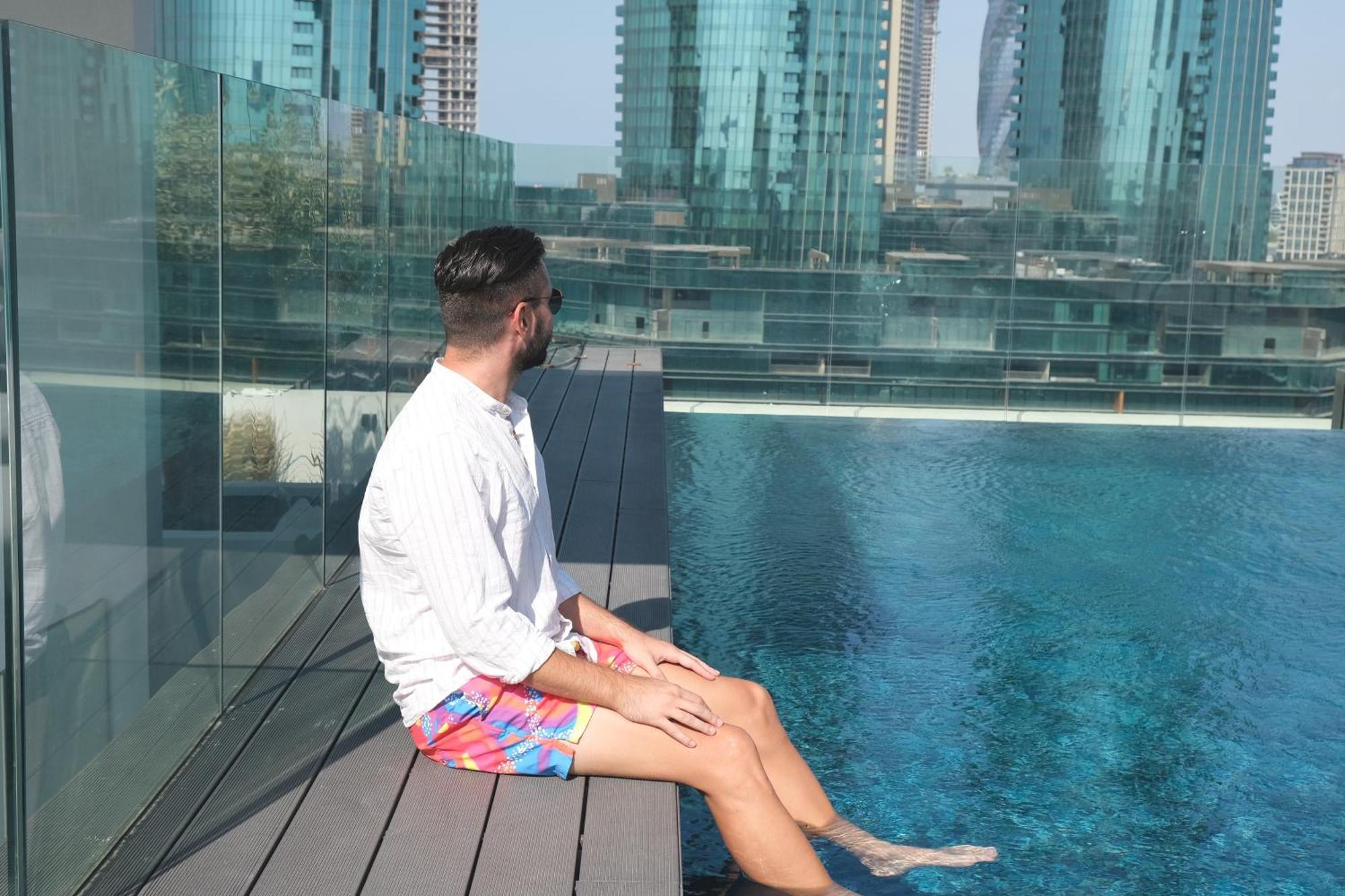 Charthouse Bahrain Hotel มานามา ภายนอก รูปภาพ A man sitting on the edge of a pool